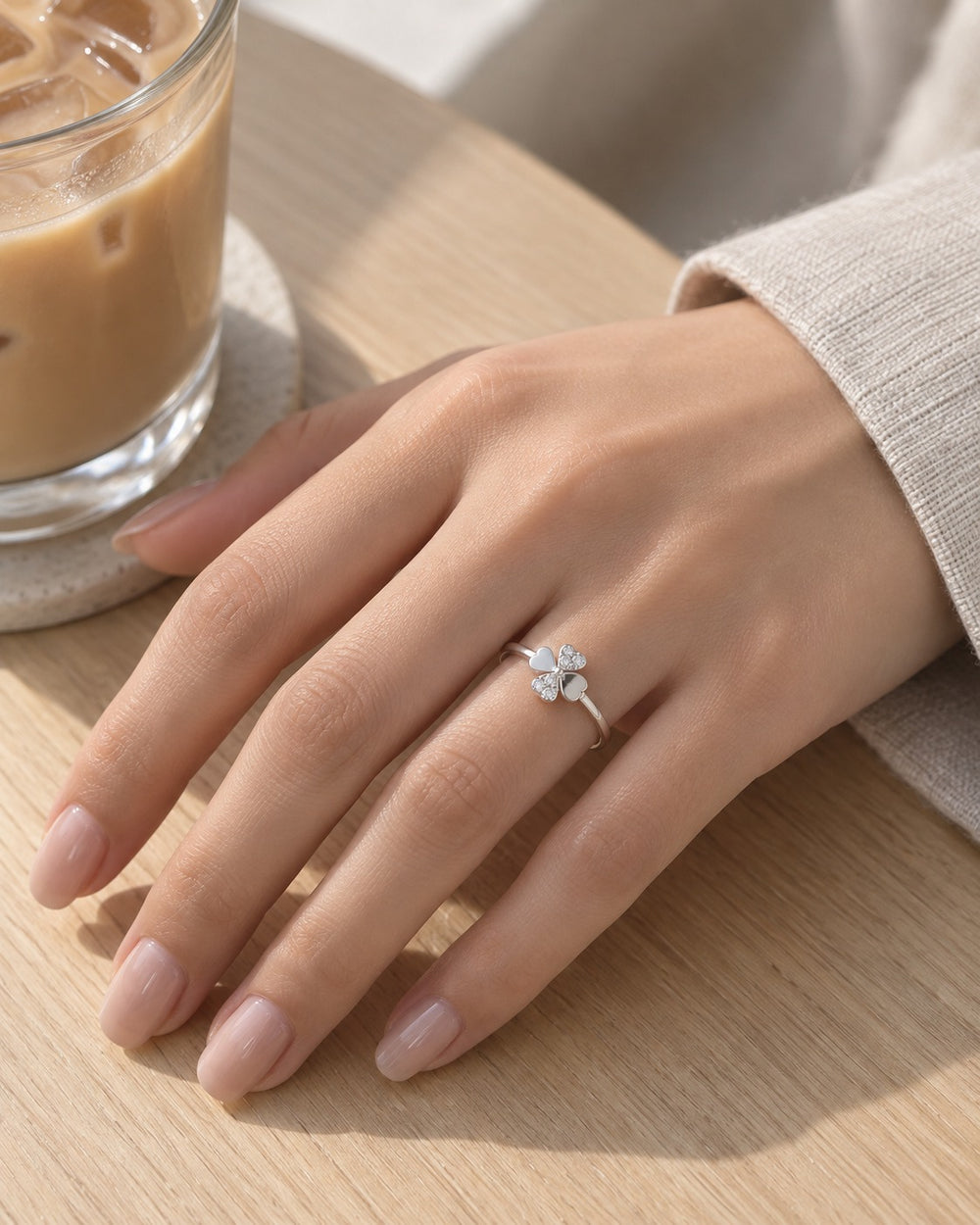 Nhẫn cỏ bốn lá 8350SV đeo tay bên ly cà phê