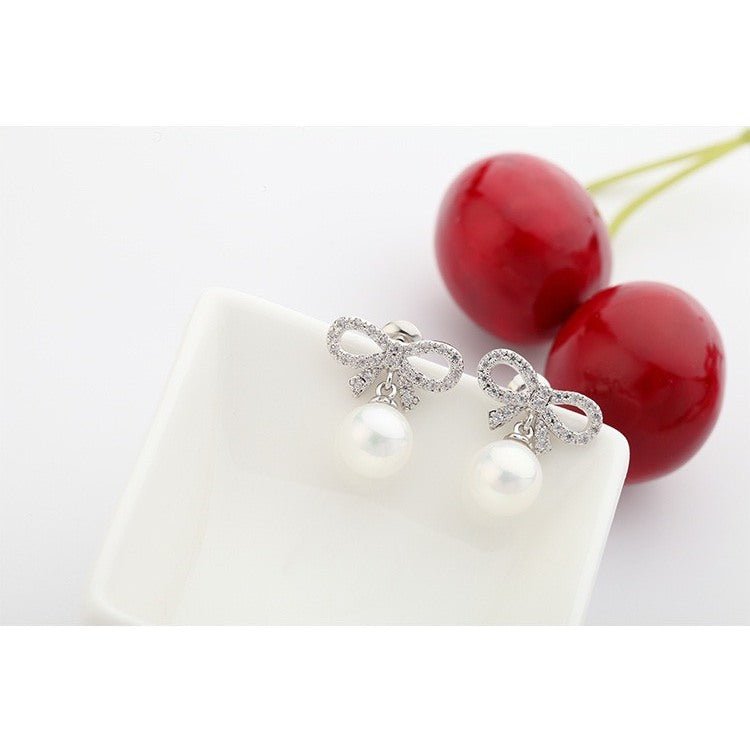 Bow-shaped and Synthetic Pearl Earrings, mỗi chiếc gồm chiếc nơ nhỏ đính đá